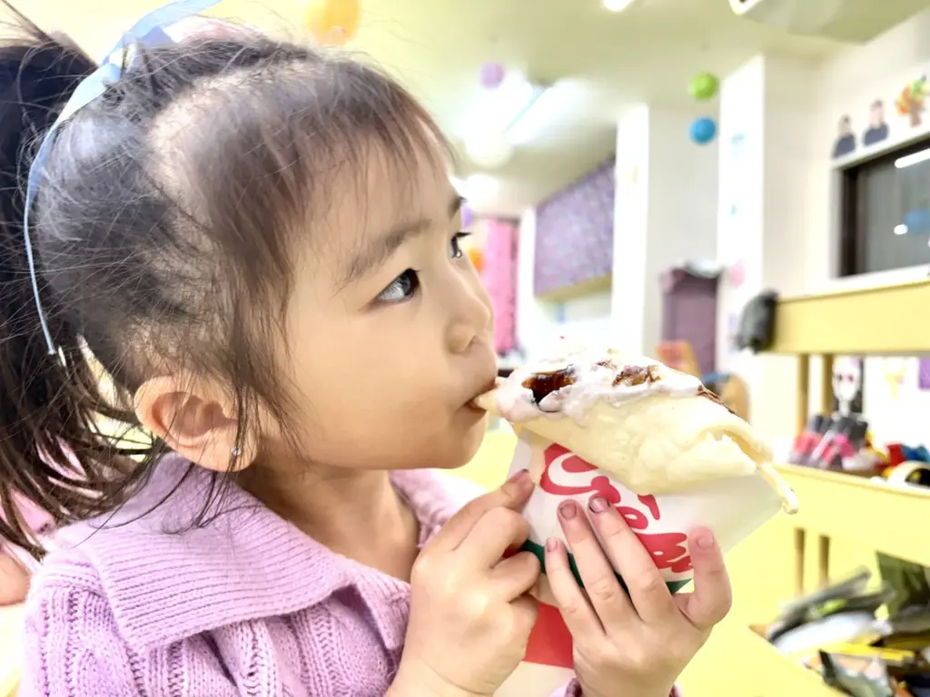 自分で作ったクレープを食べる女の子